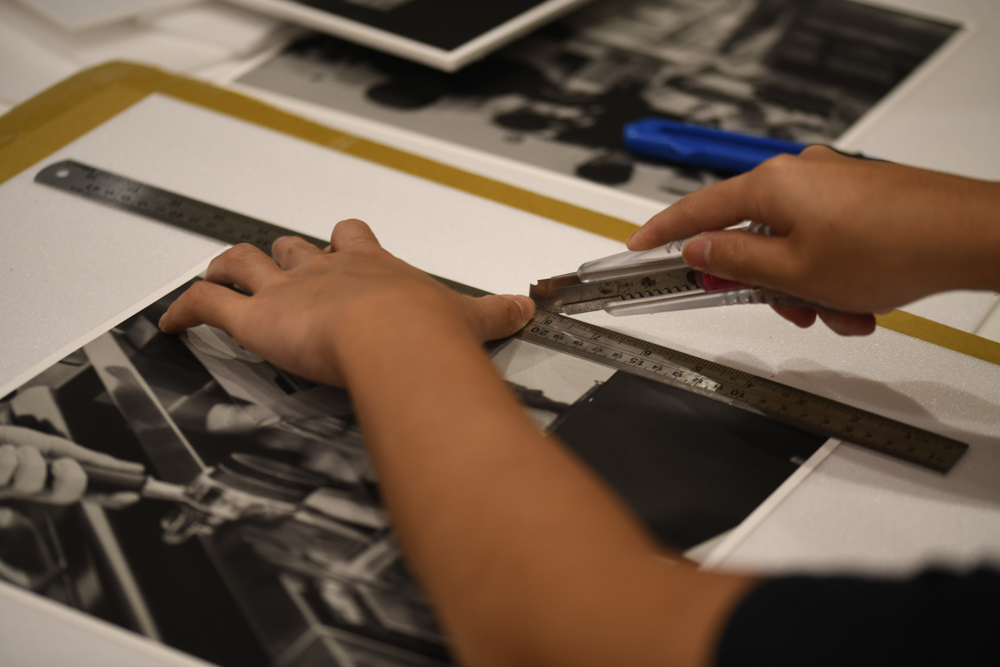 Then, they trimmed off the excess of the boards. Afterwards, they attached plastic hooks to the back of the boards while having to follow very specific dimensions. (Photo by Alden Boon)