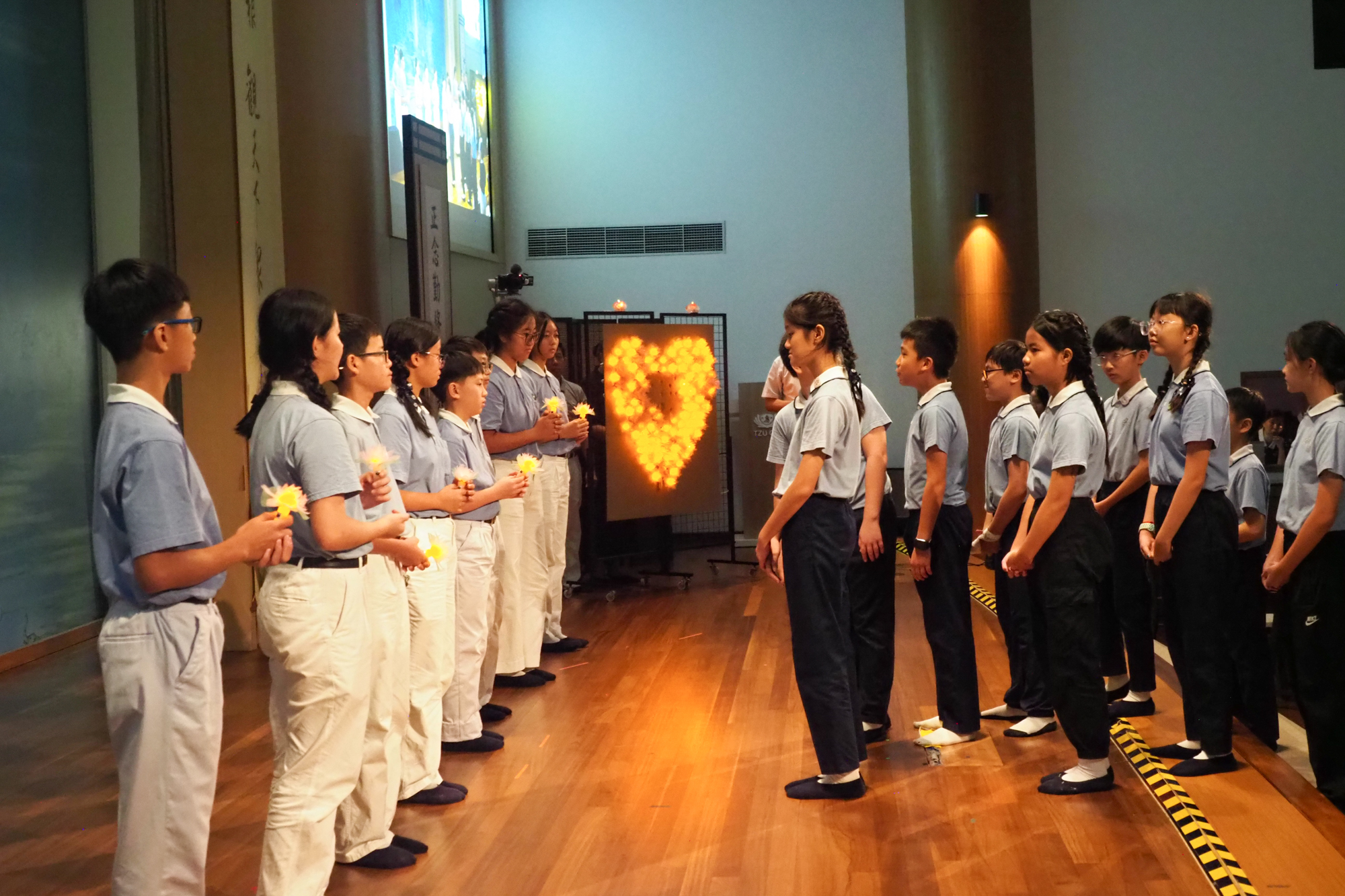 Graduates of the Parent-Child Bonding Class pass on the Lotus Lamp of Wisdom, which signifies the attainment of enlightenment. (Photo by Tay Zhi Ming) 